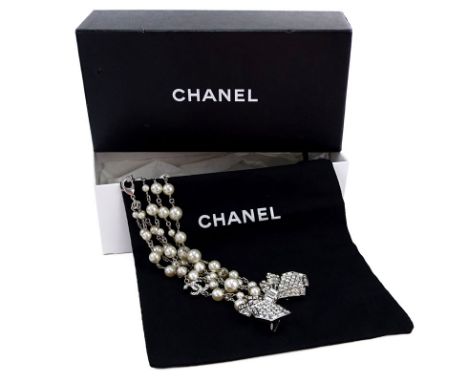 Chanel Faux Pearl, Crystal Bow, CC Three Strand Necklace. Signed. Like New Condition. Measures 20" L. Includes original bag a