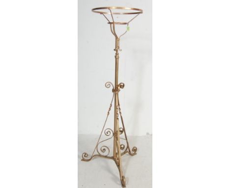 An antique early 20th century adjustable oil lamp stand / jardiniere having a scrolled decoration raised on a tripod base pai