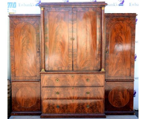 Early 19th Century flame mahogany triple wardrobe with central linen press above chest of 3 long drawers, stamped 'Wilkinson 