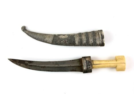 An Ottoman, or other Asian, Jambiya with marine ivory handle and curved blade; the white metal scabbard, decorated with coast