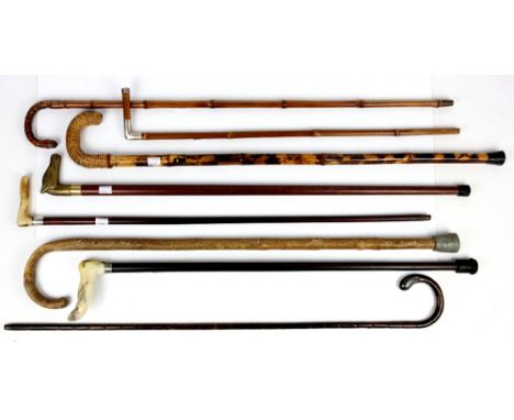 Quantity of 8 walking sticks and canes including a cane the handle in brass formed as a horse's head unscrewing to reveal a g