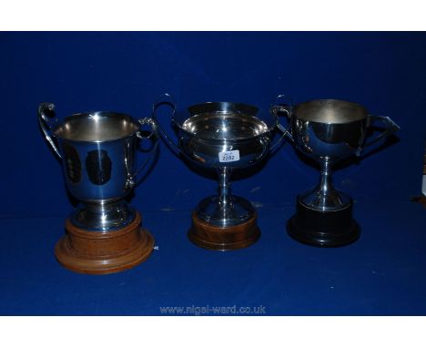 Three two-handled E.P.N.S. trophy cups together with plinths and in good order, 10 1/4", 11 1/2" and 12 1/4" tall approx.