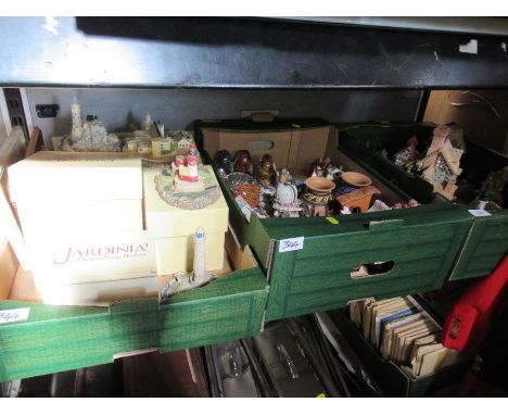 Three boxes of sundry ornaments, to include cottages, glass paperweights, light houses, Jardinia, patch boxes etc