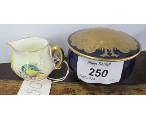 A Royal Worcester patch box, decorated with a peacock to a blue ground, together with a miniature Royal Worcester jug, decora