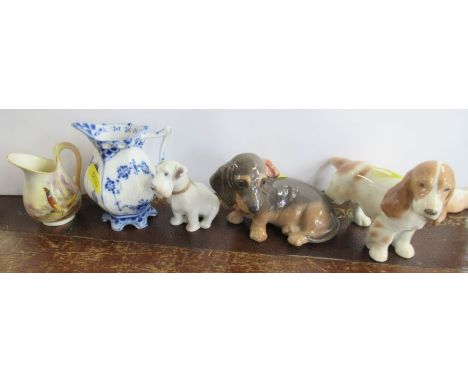 A Royal Worcester blush ivory jug, decorated with a pheasant, together with another jug and three models of dogs - All pieces