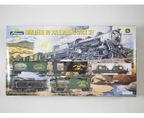 An ATHEARN John Deere HO gauge rolling stock set comprising 40' Flat Car with 2x 1:87 Scale Model B Die Cast Tractors, 3-Box 