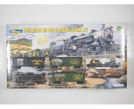 An ATHEARN John Deere HO gauge rolling stock set comprising 40' Flat Car with 2x 1:87 Scale Model B Die Cast Tractors, 3-Box 