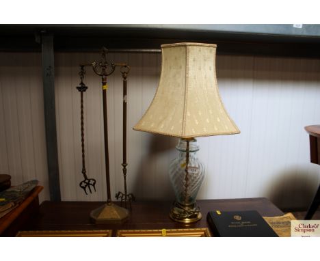 A glass table lamp together with toasting forks on stand