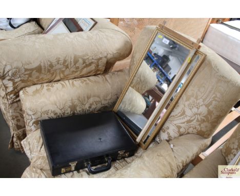 A tapestry frame; a wall mirror and a briefcase