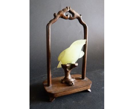 An Early 20th Century Chinese Jade Model in the form of a Bird, on a hardwood stand, 14.5 cms tall