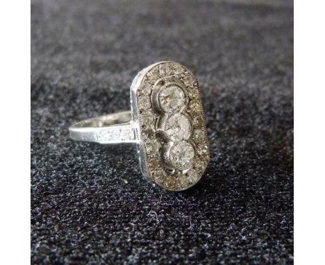 An 18ct. White Gold Art Deco Style Diamond Plaque Ring with three central diamonds surrounded by diamonds within a pierced se