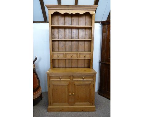 A 20th Century Pine Dresser, the boarded shelf back with three spice drawers above two short drawers and two cupboard doors r