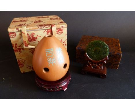 A 20th Century Chinese Jade Circular Panel upon hardwood stand within fitted box together with a Chinese Xun within fitted bo