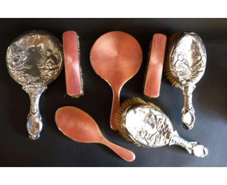 A Silver Backed Dressing Table Set comprising a pair of brushes and a hand mirror, together with a four piece silver and enam