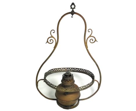 A hanging brass oil lamp with opaque glass shade and scrolling decoration to the sides.