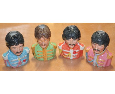 Four ceramic models of The Beatles in Sgt. Peppers uniforms.