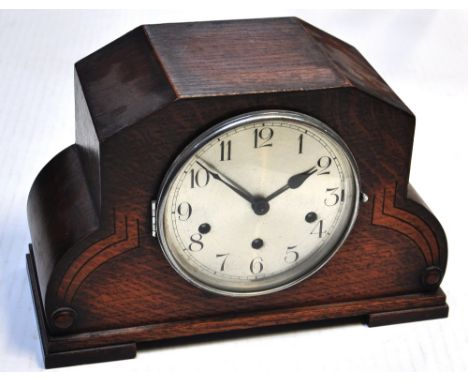 A 20th century oak cased mantel clock with Art Deco decoration, the dial set with Arabic numerals.