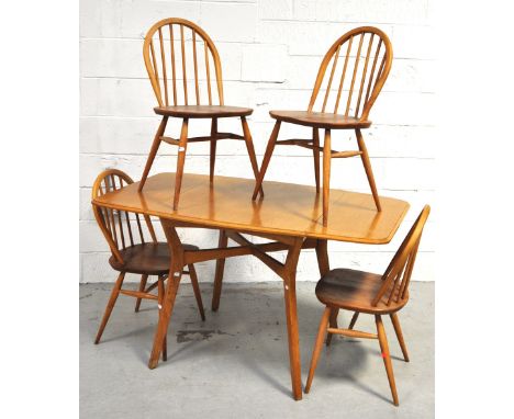 A retro 1970s light oak Ercol style dining table with twin flaps, together with four matching Ercol style stick back chairs. 