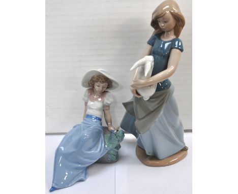 A Nao figure of a young girl with a rabbit and a Nao figure of a girl watching a bird on her hand (2).