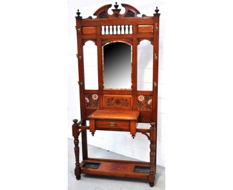An early 20th century oak hall stand with central drawer flanked by two umbrella holders the broken arched pediment flanked b