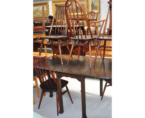 A 20th century oak dining table with fluted legs, length fully extended 148cm and five priory comb back dining chairs with ta