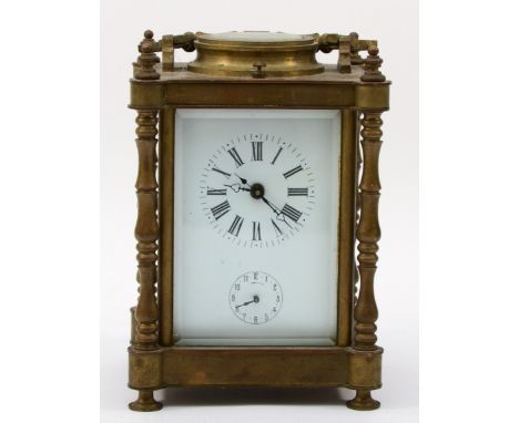 A 20th century brass corniche cased quarterly striking and repeating alarm carriage clock, with turned supports, the dial whi