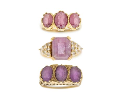 Two 9ct amethyst set dress rings and a silver gilt amethyst set three stone ring. One 9ct ring with a rectangular cut amethys