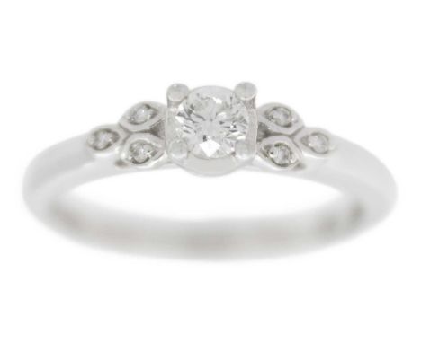 A 9ct white gold diamond solitaire ring by Emmy of London.  Set with a 0.16ct round brilliant cut diamond, the shoulders set 