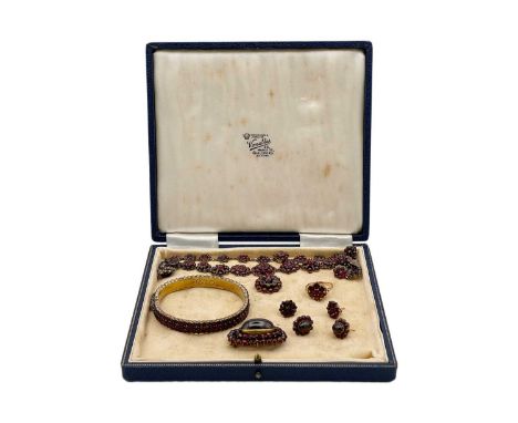 A suite of Bohemian silver gilt garnet set jewellery. Comprising a pendant necklace, length 43cm, a hinged bangle, an oval br