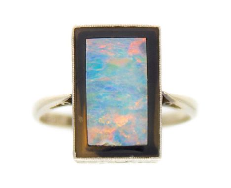 An Art Deco 18ct white gold and platinum, blue opal and black onyx set panel ring. The rectangular head millegrain set with a