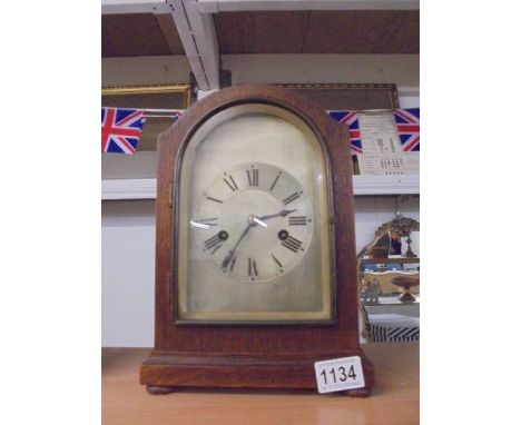 An oak cased clock with silvered dial complete with pendulum and key.