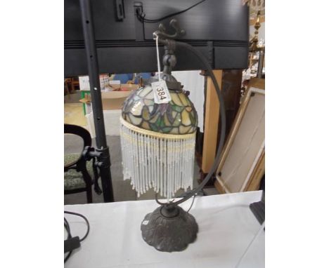 A desk lamp with Tiffany style beaded shade.
