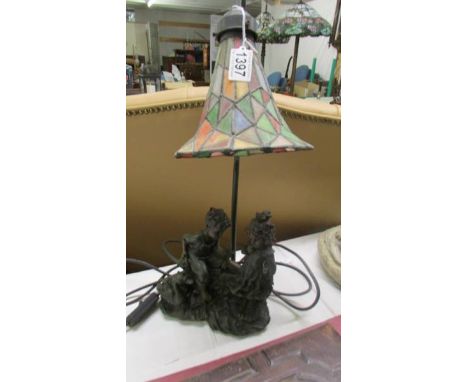 A table lamp featuring a boy, girl and duck with a Tiffany style shade.