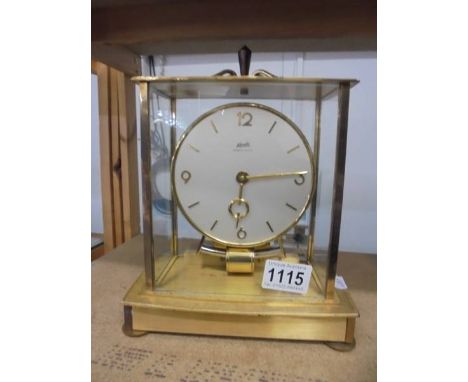 A Kundo electro magnetic clock in glass and brass case, 6 jewels, in working order.