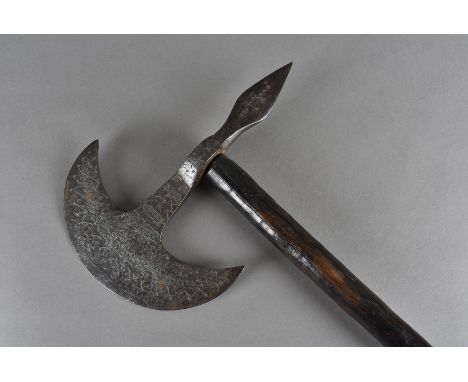 A 17th Century Indian axe, the crescentic blade and spike both having engraved decoration, mounted on wooden handle, 70cm lon
