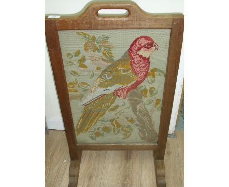 Robert Thompson 'Mouseman' oak fire screen with inset wool work embroidered panel of a parakeet (47cm x 82cm) 