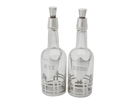 Two American glass decanters with silver coloured overlay, the tapering stoppers stamped Sterling, the overlay with shield sh