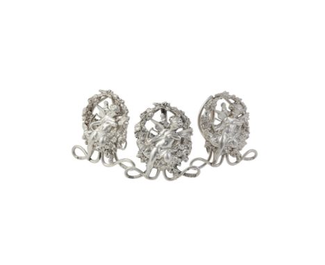 A matched set of three menu holders by William Hutton & Sons Ltd., London 1895 (1) and 1903 (2), formed as cherub among folia