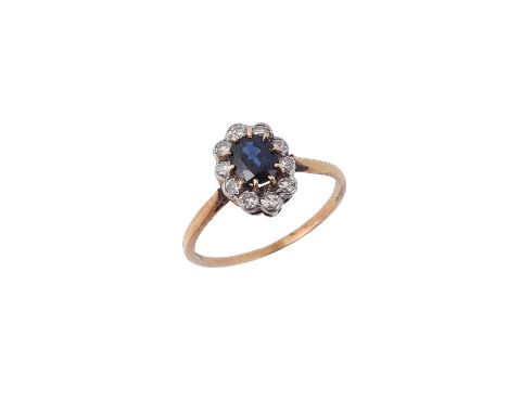 A sapphire and diamond cluster ring, the central oval cut sapphire claw set within a surround of eight cut diamonds, approxim