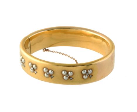A late 19th century French half pearl and rose cut diamond trèfle bangle, circa 1880, the trios of half pearls with rose cut 