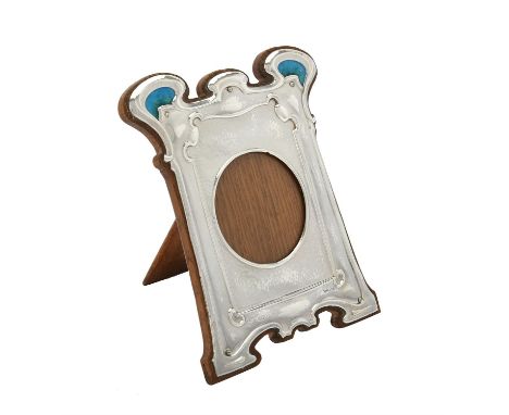 An Art Nouveau silver mounted and enamel shaped rectangular photo frame by William Hutton & Sons Ltd., London 1907, the centr