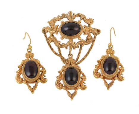 A pair of 1960s garnet earrings and brooch, the brooch with a pierced oval panel set with an oval cabochon garnet, suspending