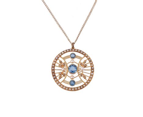An Edwardian seed pearl and aquamarine pendant, circa 1910, the pierced circular panel set with three graduated circular cut 