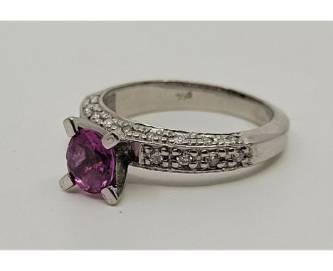 An 18ct. white gold, pink sapphire and diamond ring, four prong set mixed oval cut pink sapphire to centre (approx. 6mm x 5mm