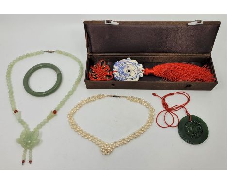 A celadon green jade pendant necklace, length 54cm, in box, together with a green jade bangle, external diameter 81mm, a carv