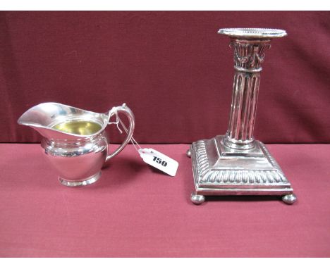 A German Candlestick, stamped with the crescent and crown and "800", the square base raised on your ball feet; A German Cream