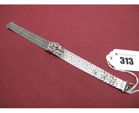 A Ruby Set Bracelet, the claw set floral spray applied to bracelet of textured finish, to snap clasp stamped "750".