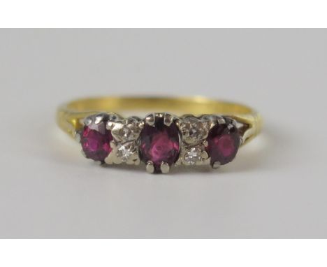 An 18ct Yellow Gold, Ruby and Diamond Ring, the principal  5 x 3.8mm stone flanked by two small diamonds either side, size N,
