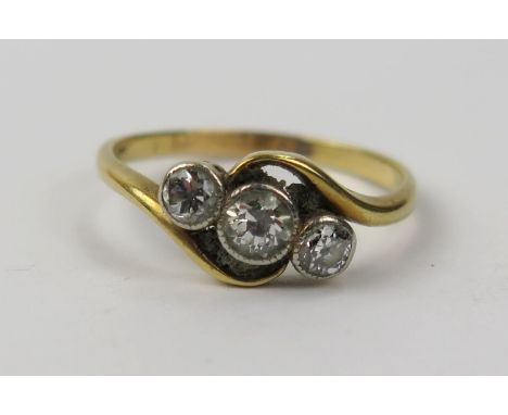 An 18ct Gold And Diamond Twist Three Stone Millegrain Set Ring, largest stone c. 3.9mm, size N.25, 2.4g 