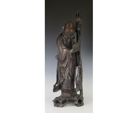 A Large and Heavy Carved Harwood Figural Lamp Base in the form of a travelling sage with stork to base, 71cm 